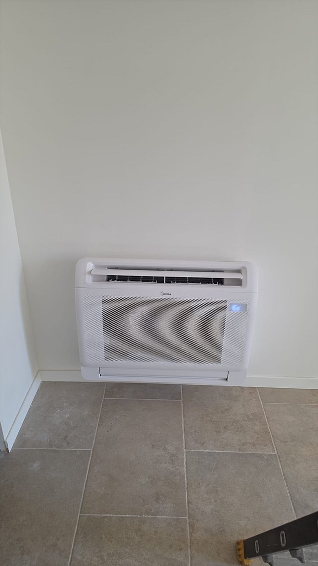 Console de pompe à chaleur réversible installée en pied de mur